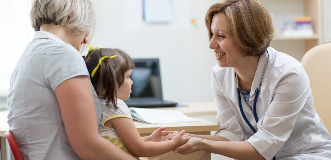 Pediatrician smiling at a young child patient