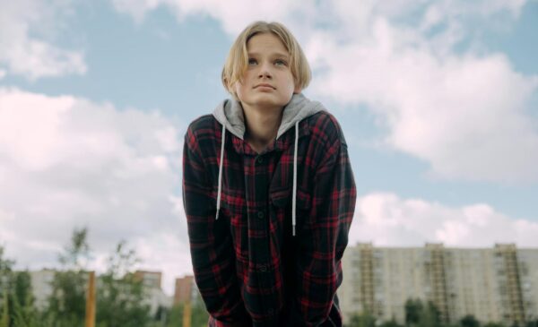 youth with plaid hoodie and hands in pocket