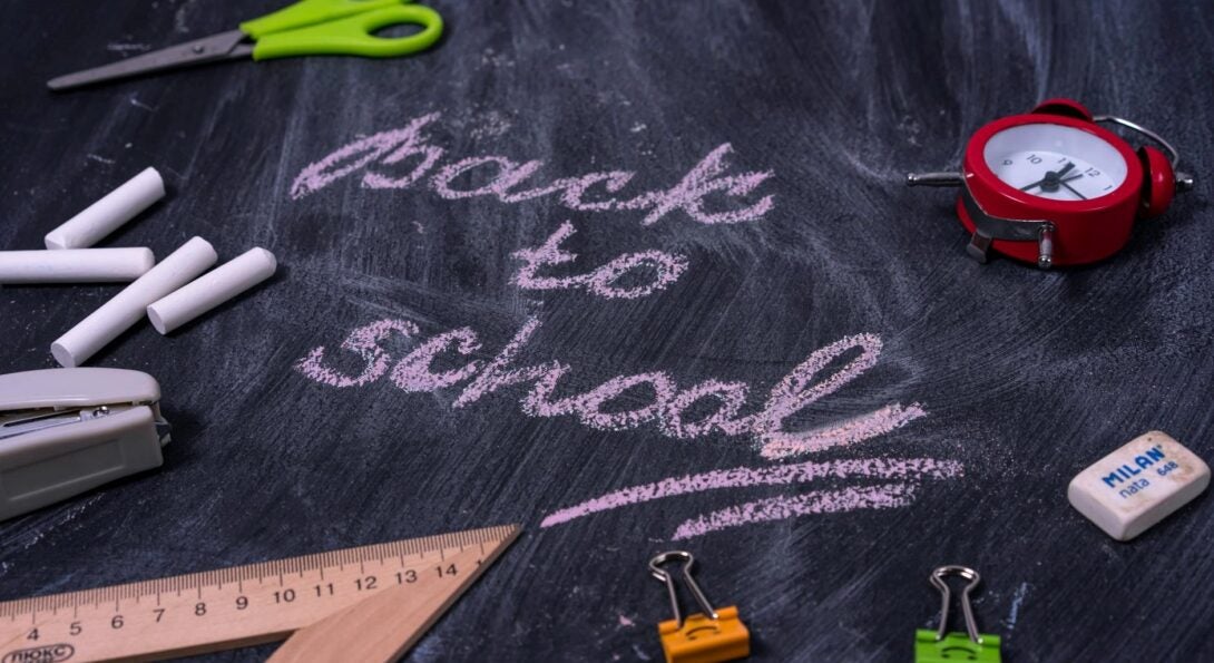 chalk board with back to school written and scissors chalk and binder clips