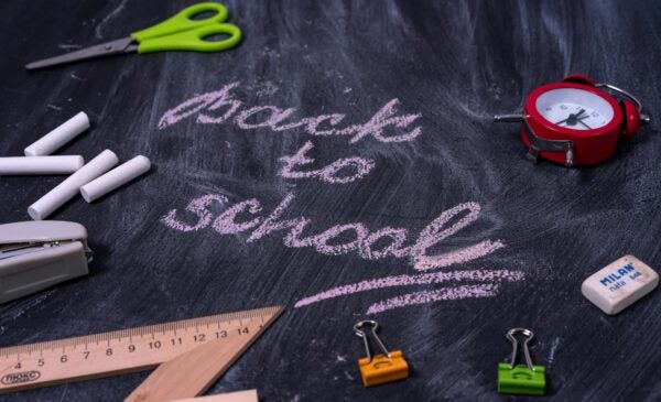 chalk board with back to school written and scissors chalk and binder clips